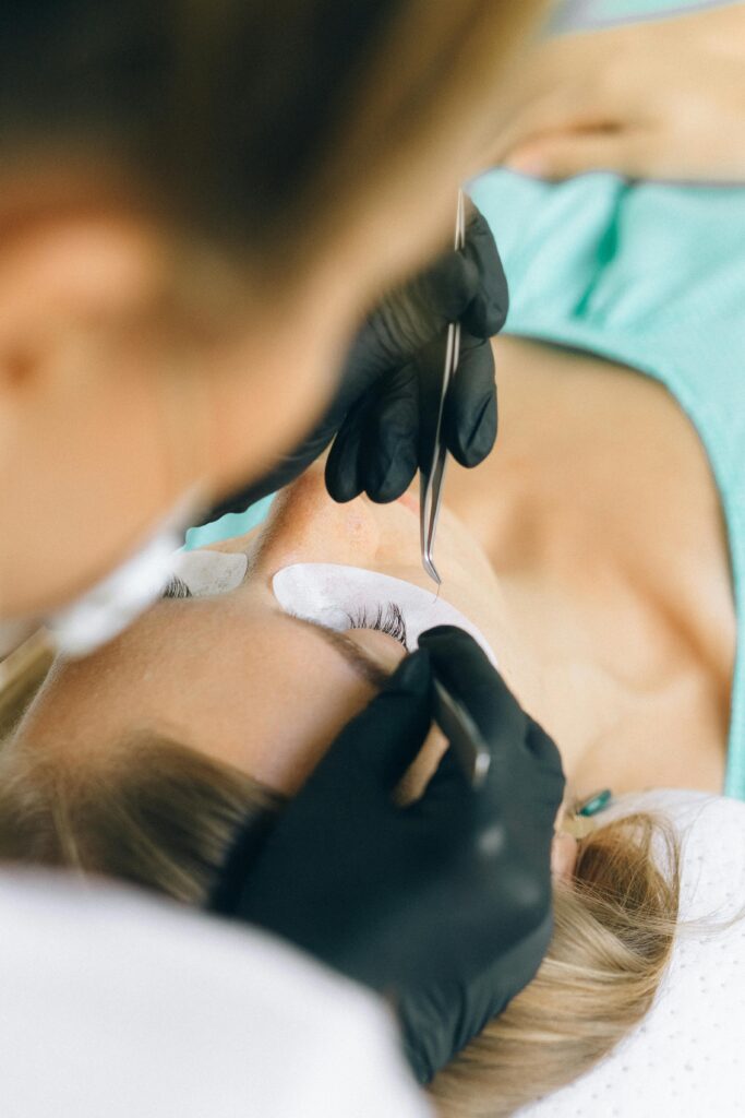 Przedłużanie rzęs – stylistka wykonuje aplikację metodą profesjonalną w salonie kosmetycznym